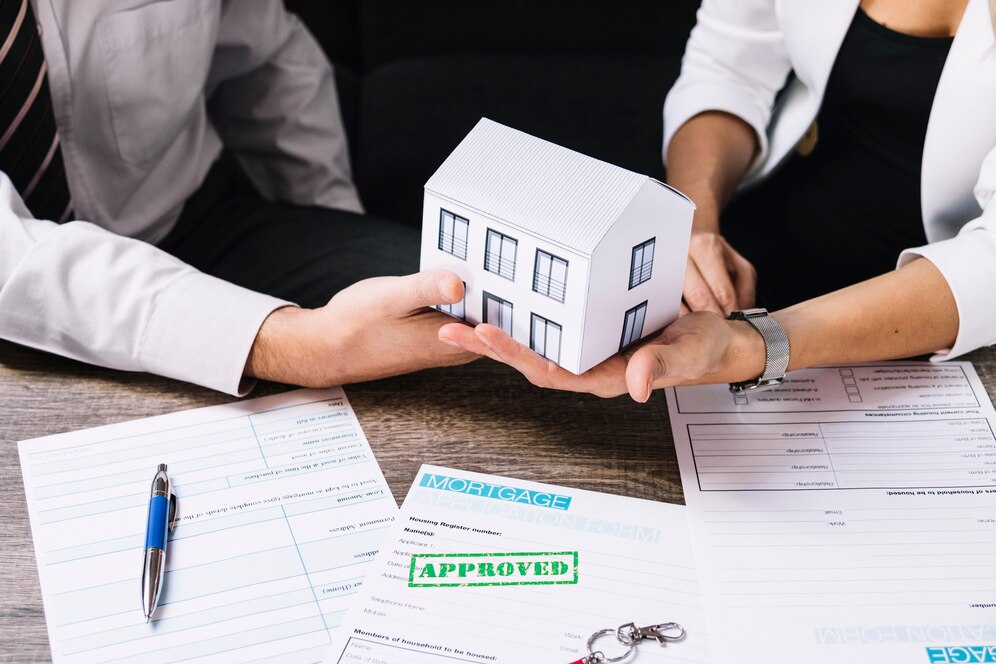 A real estate agent is presenting a small model house to a client, symbolizing the successful approval of a mortgage application. A real estate agent is presenting a small model house to a client, symbolizing the successful approval of a mortgage application.
